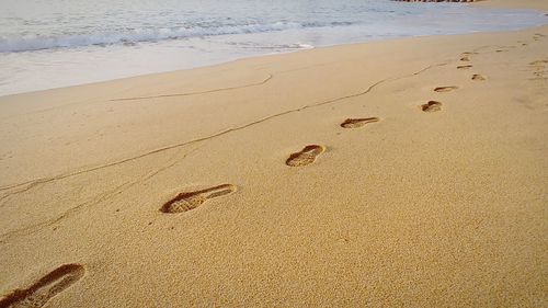 High angle view of footprints on sand at beach