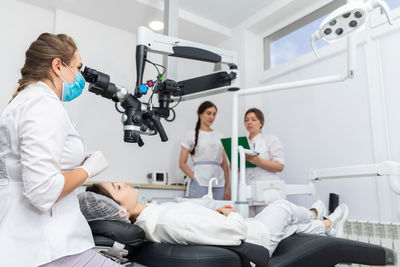 Side view of doctor operating patient at clinic