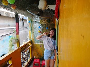 Young woman standing against wall