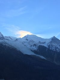 Scenic view of snowcapped mountains against blue sky