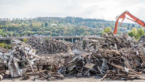 Stack of logs on field against sky