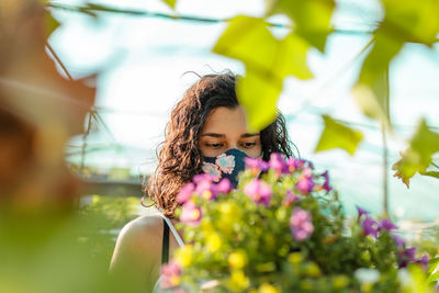 Young woman with pink flower in sunlight