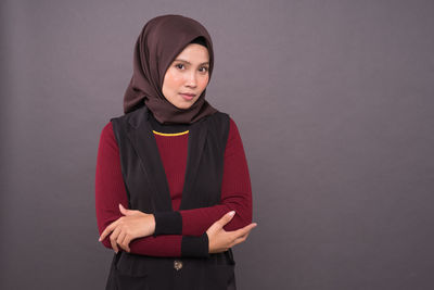 Portrait of a smiling young woman against gray background