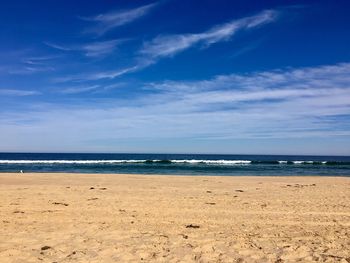 Scenic view of beach against blue sky