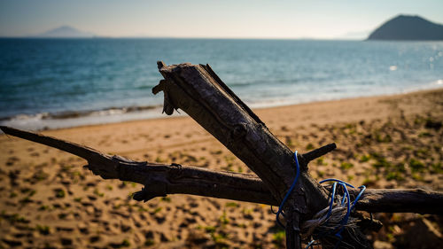 Rusty metallic structure on beach against sky