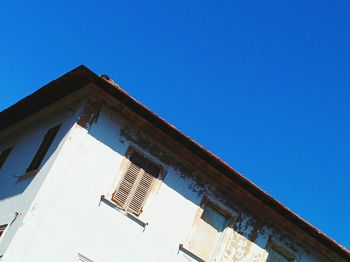 Low angle view of old building against clear blue sky