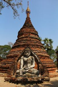 Low angle view of statues on building against sky