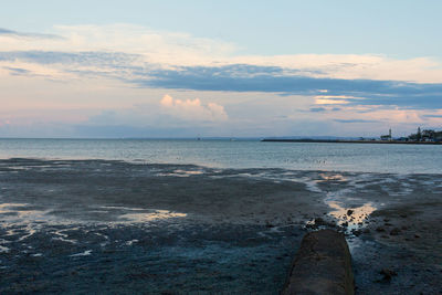 Low section of beach against sky during sunset