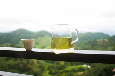 Close-up of drink on railing