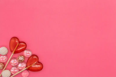 Directly above shot of pink petals against red background