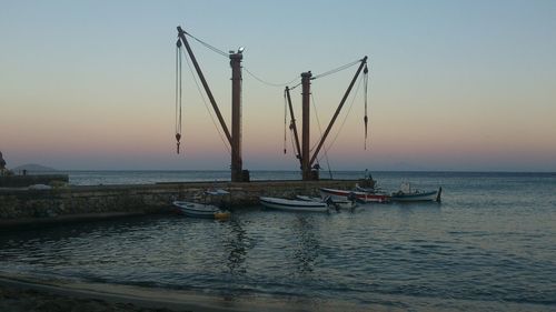 Boats in sea at sunset