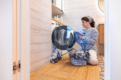 Rear view of woman standing in bathroom