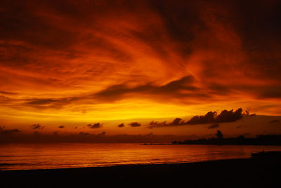Scenic view of sea against dramatic sky during sunset