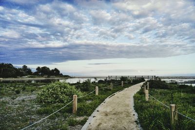 Scenic view of field against cloudy sky
