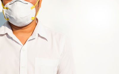 Midsection of man standing against white background