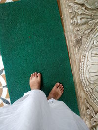 Low section of man standing on doormat