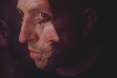 Close-up of man against black background