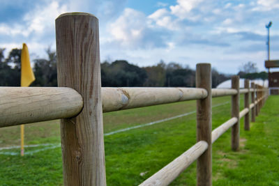Wooden fence on field against sky