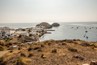 High angle view of sea and buildings against clear sky