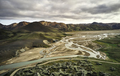 Overcast sky over highlands with river and road