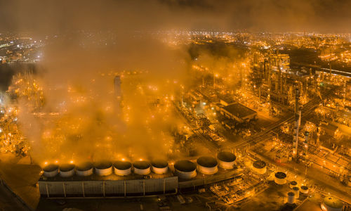 Refinery and steam glowing orange in night aerials