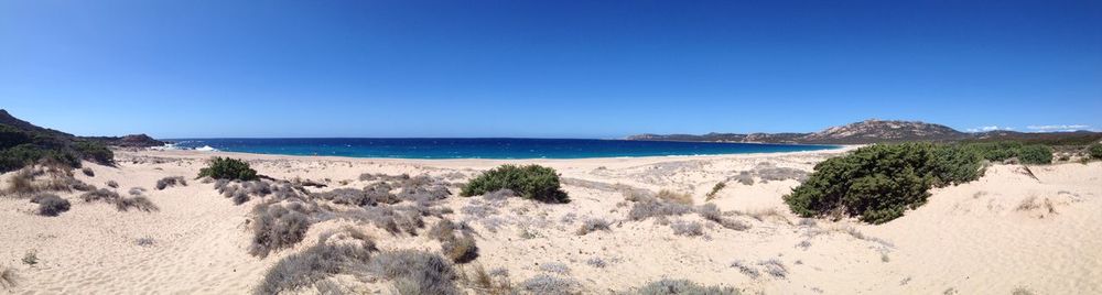 Panoramic view of beach against clear blue sky