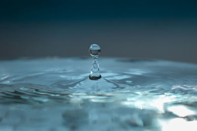 Water droplet rises after falling on blue surface