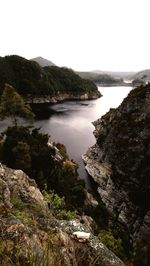 Scenic view of sea and mountains against clear sky