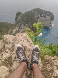 Low section of person on rock by sea