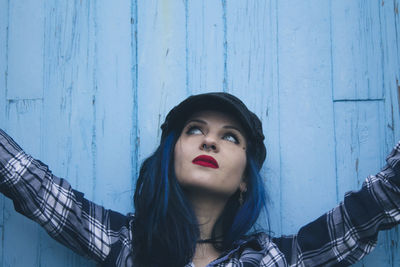 Young woman in blue wall