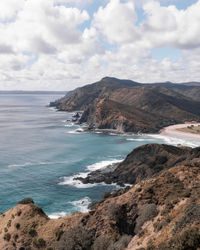 Scenic view of sea and mountains against sky