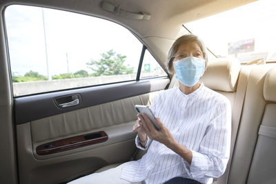 Woman using mobile phone while sitting in car