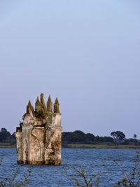 Castle by sea against clear sky