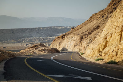 Road leading towards mountains against sky