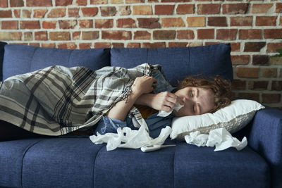 High angle view of young woman sitting on sofa at home