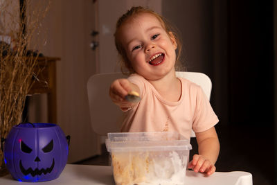 Portrait of cute girl with food at home