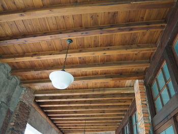 Low angle view of illuminated light hanging from ceiling of building