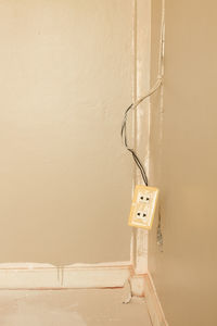 Low angle view of electric lamp hanging on wall