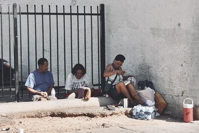 People sitting against wall