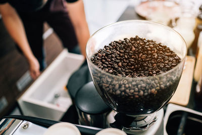 Organic coffee beans into an electric coffee grinder. preparation for making fresh coffee.