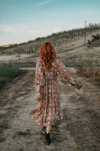 Redhead woman walking on a countryside path