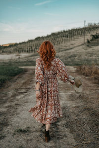 Rear view of woman standing on field