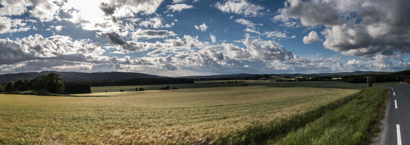 Scenic view of field against cloudy sky