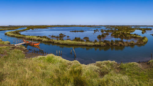 Scenic view of lake against clear blue sky