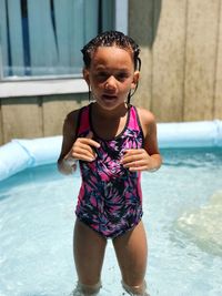 Portrait of cute girl standing in swimming pool