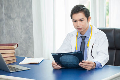 Mid adult man using laptop on table