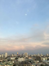 Buildings in city against sky during sunset