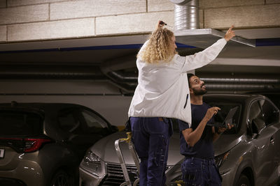 Man and woman checking air duct