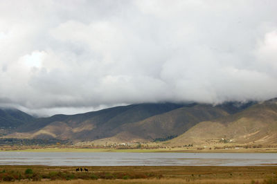 Scenic view of lake and mountains against sky