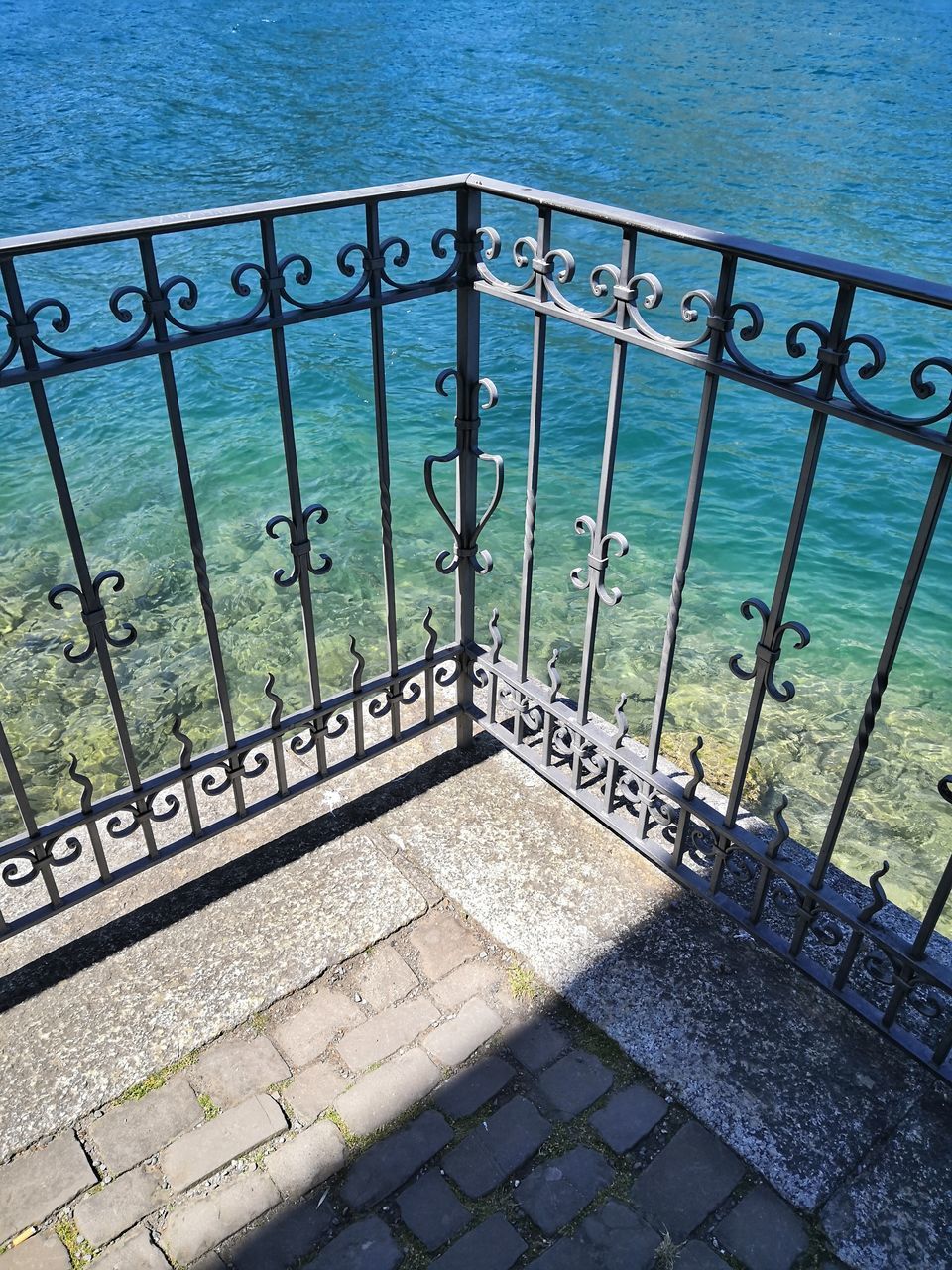 HIGH ANGLE VIEW OF CLOSED GATE AGAINST SEA